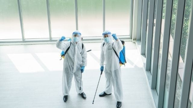 two people dressed in cleaning suits