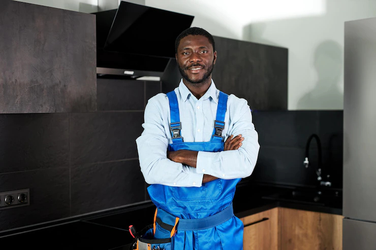 man in blue overalls with crossed arms